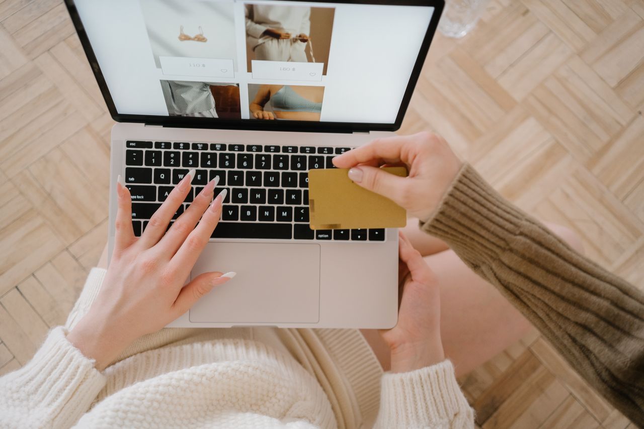 Personne faisant des achats en ligne avec un ordinateur portable et une carte de crédit, mettant en avant la simplicité du e-commerce.